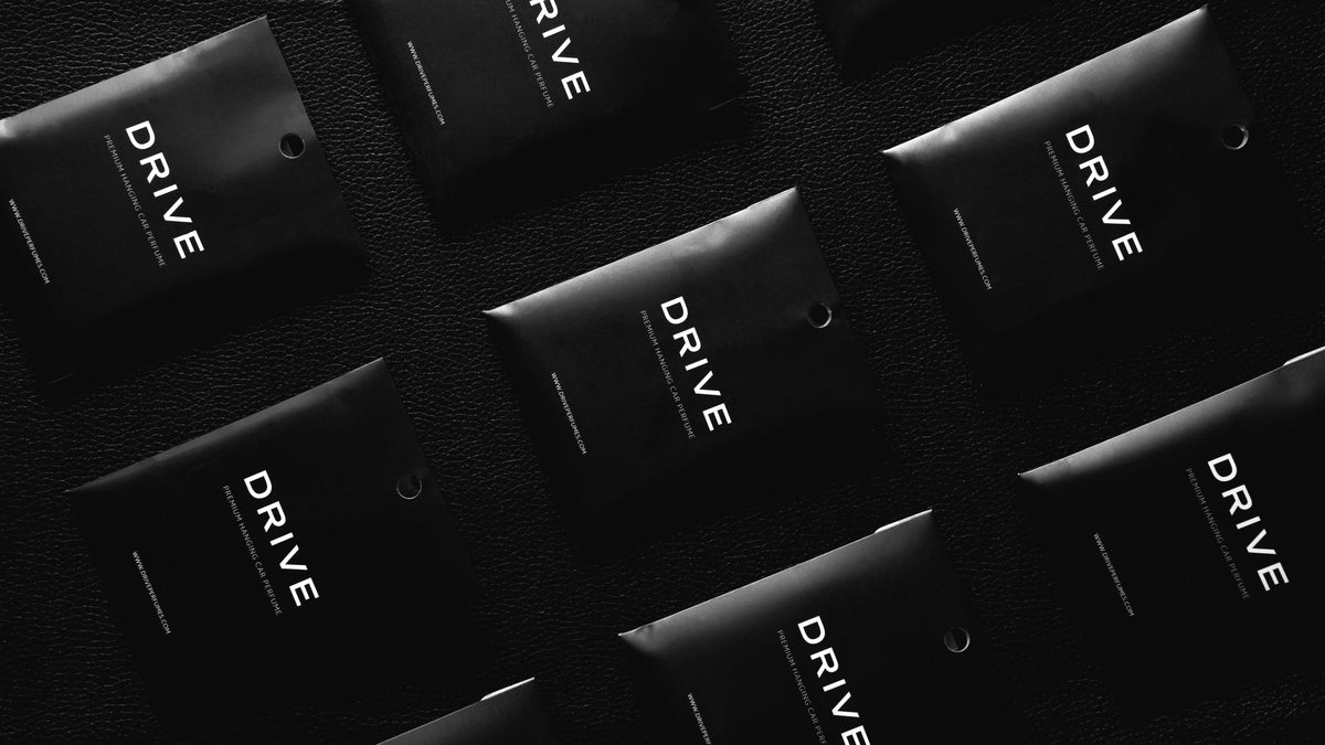 Drive car perfume envelopes laid out on a black surface