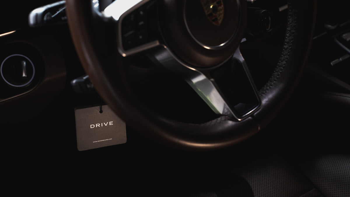 Drive hanging car perfume card behind a Porsche steering wheel